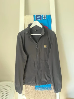 Windbreaker Jacka från Belstaff - Snygg svart vindjacka från Belstaff. Den är i bra skick. Köpte den nyligen för runt 2000kr.