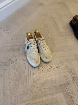 Beige sneakers från Axel Arigato - Snygga beige sneakers från SWC Klassisk låg modell med vita snören och vit sula. Perfekta för dig som gillar stilrena och trendiga skor med en clean look.