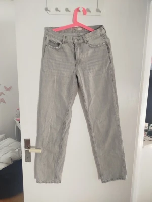 Ljusgrå raka jeans - Säljer ett par ljusgrå jeans med rak passform från Gina Tricot i storlek 34.. Tillverkade i denim, perfekta för en avslappnad och trendig look.