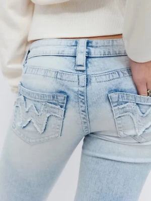 Ljusblå bootcut jeans med fransade fickor - Säljer ett par ljusblå bootcut jeans med slitna detaljer och fransade bakfickor med ett vågmönster. Jeansen har väldigt låg midja och klassisk femficksdesign. Materialet är denim i bomull med en mjuk tvättad finish. Det är Gina Tricots 14+ ultra low waist, använda 3 ggr