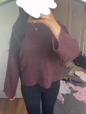 Vinröd  stickad tröja - Mysig vinröd stickad tröja. Tröjan har rund halsringning och är tillverkad i ett mjukt material som känns skönt mot huden. Perfekt för lager på lager och en avslappnad look.