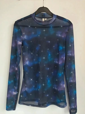 Mesh topp med galaxmönster💜💙 - Snygg mesh topp med lång ärm och ett coolt galaxmönster i blått, lila och svart. Toppen är tight och genomskinlig, perfekt att styla lager på lager. Materialet är stretchigt och lätt, vilket ger en bekväm passform. Skriv vid frågor 💌