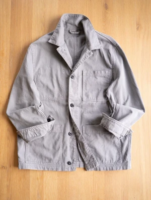 Grå Chore Jacket med stora fickor - Snygg grå overshirt i bomull med fyra stora utanpåliggande fickor och knäppning framtill. Rak passform och klassisk krage ger en clean och avslappnad look. Perfekt att slänga över en hoodie eller t-shirt för en casual vibe.