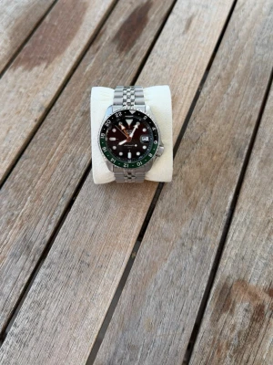 Seiko automatic gmt  - Till salu är en Seiko Automatisk GMT från 2025 har använt den 10 gånger kvitto och box fås med.  En modern klassiker som kombinerar japansk precision med tidlös design. Klockan drivs av Seikos pålitliga automatiska GMT-verk, vilket innebär att den laddas av handledens rörelser och erbjuder möjligheten att följa två tidszoner samtidigt – perfekt för resor eller den som uppskattar GMT-funktionen.   