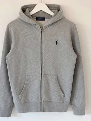Grå zip hoodie från Polo Ralph Lauren - Tjena, jag säljer en riktigt snygg Ralph Lauren zip hoodie☺️ Den är självklart äkta✅ Den är i mycket bra skick och har inga fläckar eller skador😁 Skicka om du har några frågor😄