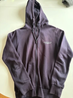 Mörkblå McKenzie set - Säljer ett mörkblått set från McKenzie med matchande hoodie och byxor. Hoodien har dragkedja, fickor och justerbar huva. Byxorna har resårmidja med snörning och fickor. Båda delarna har McKenzie-logga tryckt på bröstet och benet. Mjukt och bekvämt material.