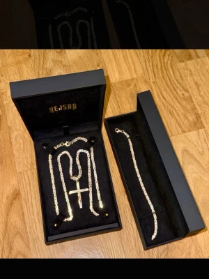 Silver halsband med kors från kejsar  - Säljer ett stilrent silverfärgat halsband från kejsar med ett stort kors som hänge. Säljer inte separat utan tillsammans, boxarna följer med! Pm ifall funderingar. 