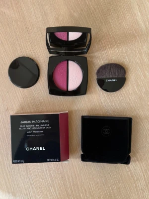 Chanel Jardin Imaginaire Rouge Duo - Chanel Jardin Imaginaire Duo Blush & Highlighter i färgen Light and Berry. Innehåller två nyanser: en bärig rosa och en ljusare rosa, båda med pressat mönster. Kommer i en elegant svart dosa med spegel, tillhörande borste och sammetsfodral. Helt oanvänt. Nypris 1000kr