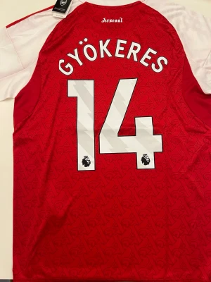 Gyökeres Arsenal 25/26 Vinnar säsong  - Fotbollströja i helt nytt och oanvänt skick med tag kvar. Detaljrik design och bekvämt material som passar både till match och vardag. Detta är en inofficiell version av modellen. Storlek L