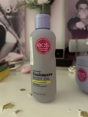 eos Cashmere Body Oil Vanilla - Lyxig body oil från eos i doften Vanilla Cashmere. Innehåller växtbaserad squalane och sheasmör som ger långvarig återfuktning och silkeslen hud. Kommer i en ljuslila plastflaska med skruvlock och röd logga. Perfekt för dig som vill ha en mjuk och väldoftande hud.