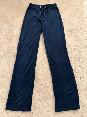 Mörkblå velourbyxor  - Mörkblå mjukisbyxor i velour från Gina Tricot med raka ben och dragsko i midjan. Perfekta för chill dagar hemma eller när du vill ha en avslappnad look. Supersköna och mjuka mot huden.