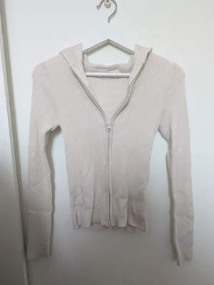 Beige ribbad zip up hoodie - Säljer en beige ribbad hoodie från Stradivarius i storlek XS. Hoodien har en dragkedja framtill, lång ärm och en smal, figurnära passform, dragkedjan är även en tvåvägsdragkedja. Tillverkad i ett mjukt, stretchigt material som känns skönt. Perfekt för en avslappnad och stilren look. Säljer den för mer än 50kr då jag köpte den lite dyrare men priset går att förhandla. Hör gärna av er vid några frågor 💕