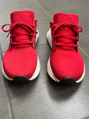 Röda Adidas sneakers med vita sulor - Snygga röda sneakers från Adidas med klassiska svarta ränder på sidan och vit, chunky sula. Ovandelen är i mesh-tyg för bra andningsförmåga och skorna har röda skosnören. Perfekta för en sportig och trendig look. Skorna har lite fläckar som jag har försökt fått bort men det är inte mycket kvar. Dessa skor är i storlek 44 och 2 tredjedelar. De är knappt använda och jag tar imot lite mindre bud vid direktköp👍