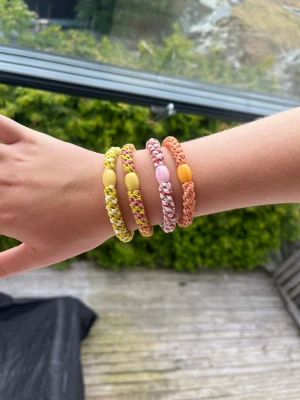 Färgglada flätade armband med pärlor - Knekkis i 4 pack rosa,orange,gul tema och orginalpris 4pack är 120kr 