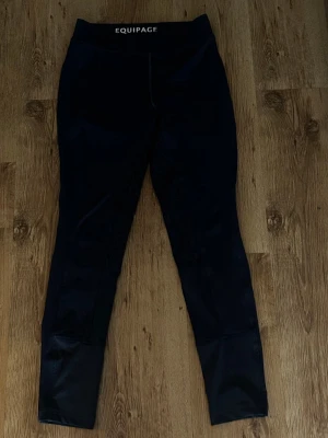 Svarta ridtights från Equipage - Snygga marinblåa ridtights från Equipage med hög midja och silikonmönster på insidan av benen för extra grepp. Tightsen har förstärkta partier vid bensluten och är tillverkade i ett stretchigt syntetmaterial som passar perfekt till ridning. ( obs ser mörkare ut på bild än vad de är)