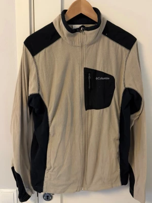 Beige fleecejacka från Columbia - Beige fleecejacka från Columbia med svarta detaljer. Använd ett fåtal gånger.