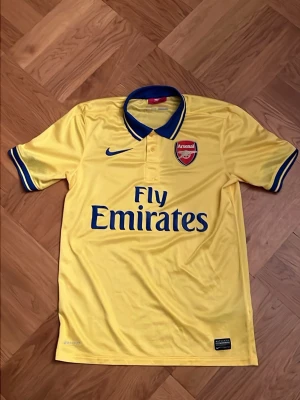 Arsenal 13/14 - Arsenal tröja från säsong 13/14, köptes för 999 kronor för ungefär ett år sen och har andvänt den en gång sen dess, otroligt skick inga hål eller missfärgningar. Det ända mista lilla är att texten på taggen är någorlunda mindre tydlig och några få lösa sömmar strax under kragen som ni kan se på dom sista 2 bilderna. Passformen är tajt i kragen och hyfsat tajt runt armarna men stretch, generellt passar den på den större sidan av S.