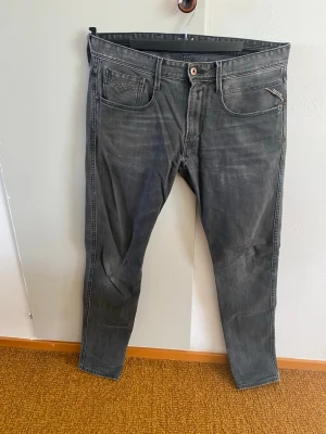 Replay - Snygga grå jeans i slim fit-modell med klassisk femficksdesign och dragkedjegylf. Jeansen har en lätt tvättad look och raka ben. Perfekta för en avslappnad och trendig stil.