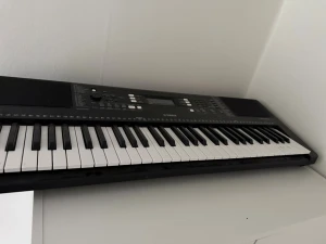 Yamaha svart digitalt keyboard - Säljer ett svart digitalt keyboard från Yamaha med 61 tangenter, LCD-display och flera kontrollknappar för olika ljud och funktioner. Perfekt för dig som vill spela musik hemma eller öva på nya låtar. Strömsladd och notställ kan köpas till separat.