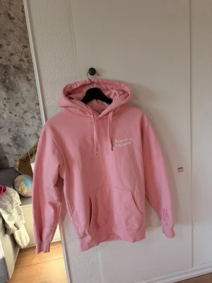 Rosa hoodie med texttryck -  Säljer en rosa hoodie från Sofias mindset. En av texterna står de: Jag ser dig, Jag hör dig, Jar är med dig. Det är meningen att de ska vara fel stavat! Köpte ny för 800kr säljer för 600 men pris kan diskuteras! 