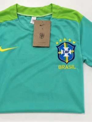 Brasilien Nike fotbollskit - Snyggt Brasilien fotbollskit från Nike med ljusgrön tröja och mörkblå shorts. Tröjan har gula detaljer och CBF-emblem på bröstet, medan shortsen har samma emblem och gula Nike-logga. Tillverkad i lätt och ventilerande material, perfekt för träning eller match.