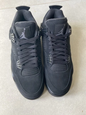 Svarta Air Jordan 4 Retro sneakers - Säljer ett par helsvarta Air Jordan 4 Retro sneakers aldrig använt 