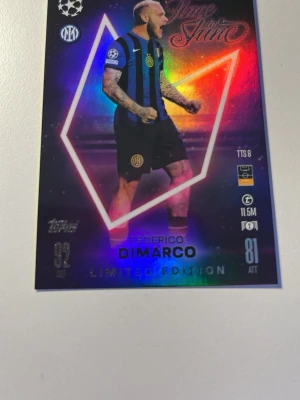 Topps fotbollssamlarbild Dimarco - Säljer en Limited Edition fotbollssamlarbild från Topps med Federico Dimarco i Inter Milans blåsvarta matchställ. Kortet har holografisk regnbågseffekt och detaljer som klubbmärke, statistik och Champions League-logga. Perfekt för samlare av fotbollskort.