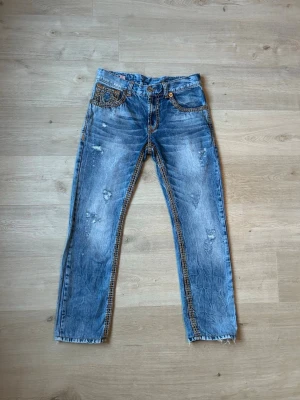 Blåa True Religion USA Straight Fit W32 - Fina True Religion Jeans i blå färg. Jeansen är i mycket bra skick och sparsamt använda. |  Äkta som allt annat jag säljer! ✅ |  Storlek: W32 | Skick: Mycket bra skick | Färg: Blå | Märke: True Religion | Modell: Jeans |  Hör gärna av dig vid frågor så svarar jag så fort jag kan! 😁|   (Sku - 42)