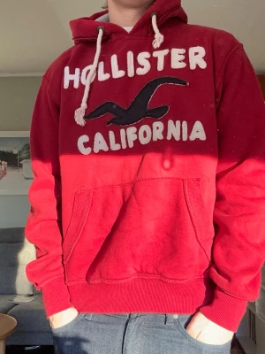 Röd hollister vintage hoodie - En snygg röd Hollister California hoodie som är lite oversized som storlek😁 Storlek M, modellen är 176cm lång. I bra skick och skön att ha på sig. Skicka gärna frågor! Mvh