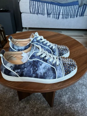 Christian Louboutin monogram  - Christian Louboutin sneaskers i färgen monogram. Storleken är 42 och skorna är i super bra skick. Skorna är välldigt sällsynta. Självklart äkta och bevis kan tas privat