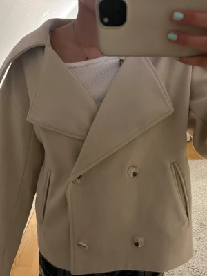 Beige skepparkavaj - Stilren beige rock med dubbelknäppning och breda slag. Tillverkad i mjuk ullmix som ger en lyxig känsla. Köpt från sellpy men kände inte riktigt att den passade mig så säljer vidare.❣️❣️❣️Buda gärna!!!