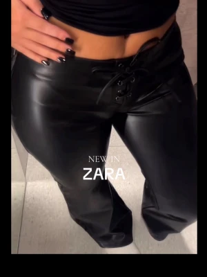 trendiga oanvända skinnbyxor från Zara - Snygga svarta byxor i fuskskinn från Zara med snörning framtill i midjan. Byxorna har utsvängda och normal i midjan. Materialet är glansigt och byxorna är små i storleken och passar mig lite oversize som vanligtvis brukar ha xs/s.  Perfekta för fest!!