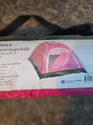 Hamra 2-manna kupoltält rosa - Säljer ett rosa Hamra 2-manna kupoltält från Rusta. Tältet är lätt att montera, har glasfiberstänger och vattenavstötande material. Praktiskt fönster med myggnät och packas smidigt i medföljande väska. Perfekt för camping eller festival. Använt ett par ggr av min dotter.