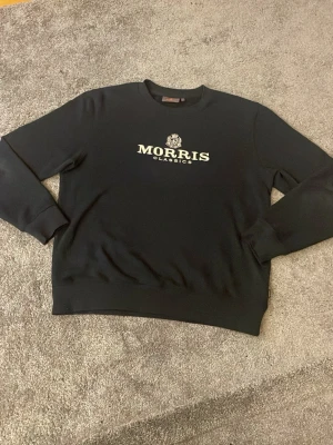 Svart sweatshirt från Morris - Säljer en mycket fet Morris tröja. Tröjan är svart med vit text. Storlek L och sitter mycket fint mot kropp. Fråga gärna ifall ni undrar något om bilder eller liknande! 