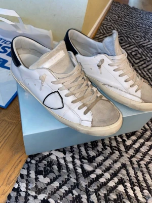 Vita philippe model - Säljer ett par Philippe models då dem inte längre kommer till användning. Skorna är använda men i fint skick. Skolådan tillkommer men är rätt sargad som man kan se på sista bilden.    Om det rycker upp några frågor eller funderingar är det bara att höra av sig🙂