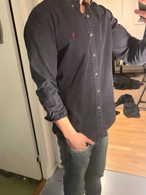 Ralph Lauren Skjorta - Tja säljer nu en Ralph Lauren Skjorta i Storlek M o färgen marinblå. Inga tydliga defekter och skjortan är i ett fint skick. Hör av dig vid frågor eller funderingar