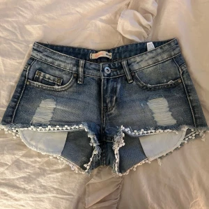 Lågmidjade trendiga jeansshorts - Otroligt snygga lågmidjade shorts som tyvärr inte passar mig. Perfekt till sommaren☀️🌸 Jättefina detaljer och har inga som helst defekter!!😽midjemått tvärsöver: 35cm. 💕FRI FRAKT på min andra annons!!