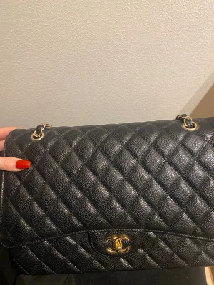 Svart väska med gulddetaljer - Säljer en klassisk svart quiltad handväska. 