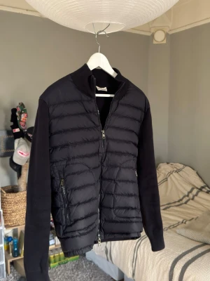 Marinblå Cardigan Moncler - Hejsan jag säljer min tre år gamla Moncler cardigan i marinblå i storlek M, den passar dig som vanligtvis har storlek S då den krympte en aning i kemtvätten och därav vill jag sälja den då den inte kommit till användning. Kvaliteten är exakt likadan. Pris kan självklart diskuteras och hojta till om du har några frågor!