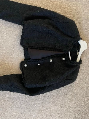 Svart tweedkavaj från Divided H&M - Säljer min jättefina vårjacka köpt från H&M i storlek S. Jackan är aldrig använd. Därav har de inga effekter. Köpt för två 299 kr men säljer endast för 50 kr.