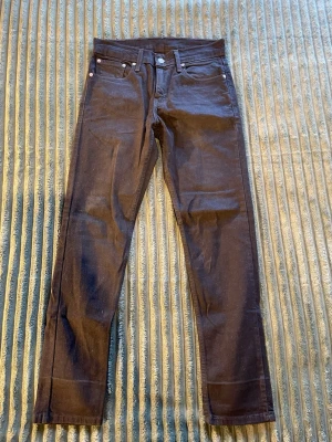 Svarta jeans från Levi's - Säljer ett par svarta jeans från Levi's med klassisk femficksdesign och silverfärgade nitar. Jeansen har normalhög midja och raka ben. Perfekta till en avslappnad streetstyle-look. W28 L30