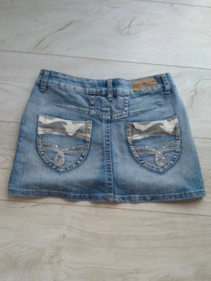 Blå jeanskjol med detaljer - Snygg blå jeanskjol med coola camouflage-detaljer på fickorna och blingade sömmar.  Passar S💕💕