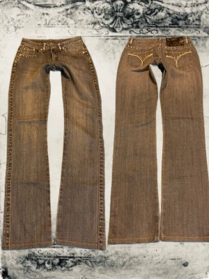 Blågrå jeans med nitar - Säljer ett par jeans med snygga nitar längs fickor och sidor. Jeansen har dekorativa sömmar på bakfickorna och är tillverkade i ett klassiskt denimtyg. Perfekta för dig som gillar en unik och trendig look. Midja 74, innerbenslängd 80.Färgen är lite missvisande, bild nummer 4 visar den riktiga färgen !