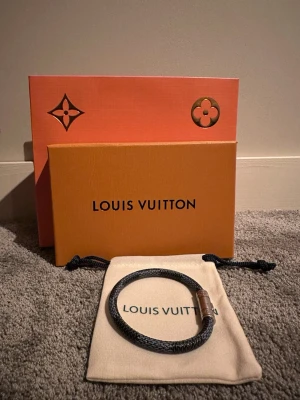 Lv armband  - Säljer detta feta lv armbandet för det är lite för tajt för mig, skick 10/10 inga defekter. Förpackning medföljer köp. Det är 20cm långt med det silvriga. Hör av er vid frågor🫡