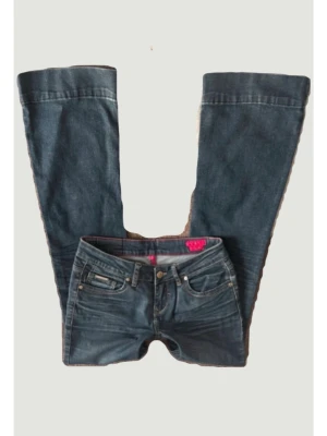 Blå bootcut jeans  - Snygga blå bootcut jeans med klassisk femficksmodell och låg midja. Jeansen har breda utsvängda ben och detaljerade sömmar. 