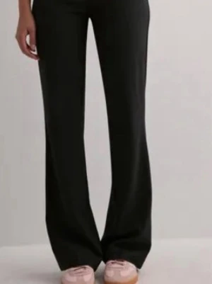 Svarta Nelly kostymbyxor  - Säljer ett par svarta kostymbyxor, bootcut och lågmidjade. Byxorna har hällor för skärp och en stilren look som passar till många olika stilar. I storlek 36 köpt för lite över ett år sedan men inte kommit till mycket användning, de är i väldigt bra skick 💕