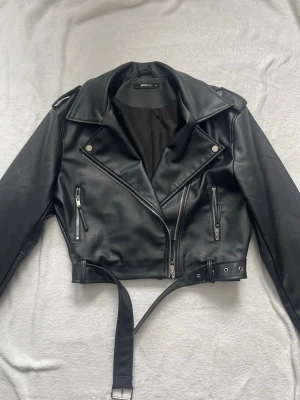 Svart skinnjacka från Gina Tricot - Snygg svart skinnjacka från Gina Tricot. Inga defekter och bara använd fåtal gånger. Ser ny ut!