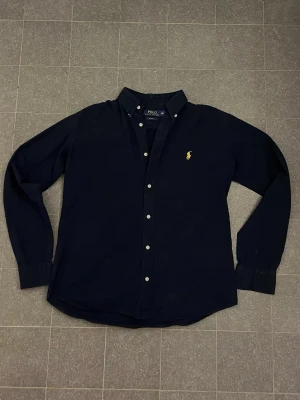 Ralph Lauren skjorta - Tjena, säljer en snygg mörkblå Ralph Lauren skjorta. Priset kan diskuteras, hör av dig vid minsta lilla fundering.