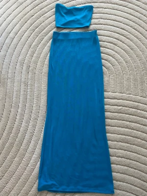 blått axelbandslös set med tight passform. - Snygg blått axelbandslös set med tight passform. Perfekt för sommarens fester. Settet är lång och har en stilren design. Storlek XXS men skulle säga att de passar en XS lika bra. Settet är från Gina Tricot men säljs inte längre💙