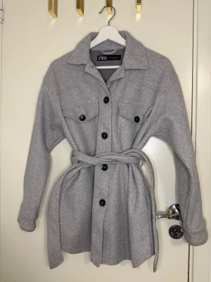 Grå kappa med bälte från Zara - Grå kappa från ZARA 🤍 Superfin passform med knyt i midjan. Perfekt till höst!